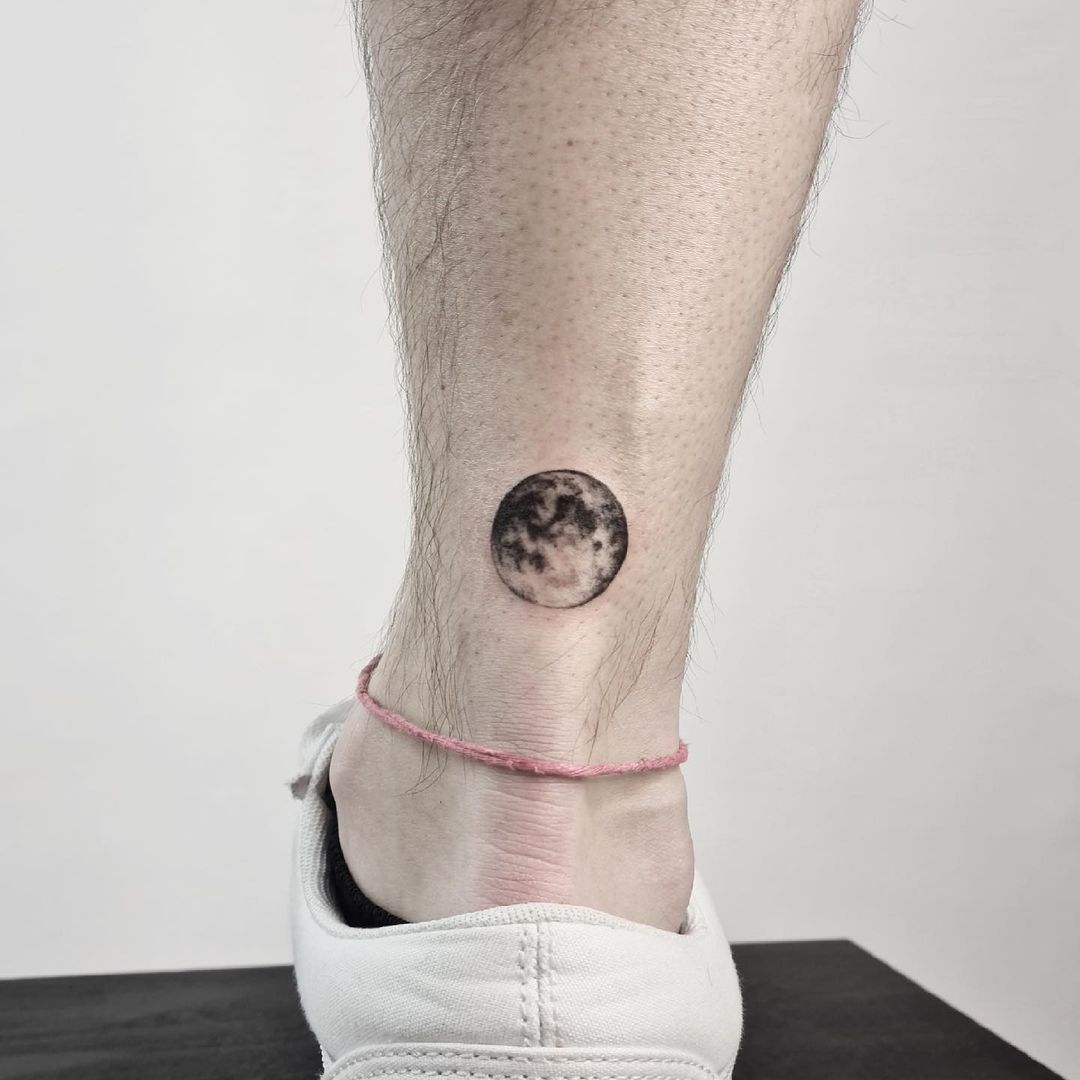 Realistic full moon tattoo on ankle. (Source: @cado.tattoo)