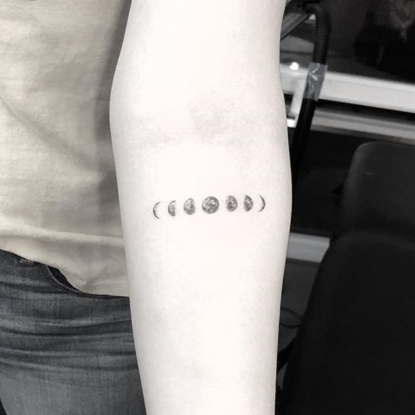 Small tattoo on arm of the different moon phases. (Source: @little.tattoos)