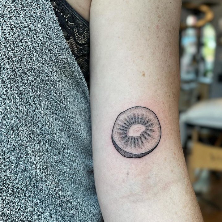Black and white kiwi fruit tattoo by @troldahl.tattoo.