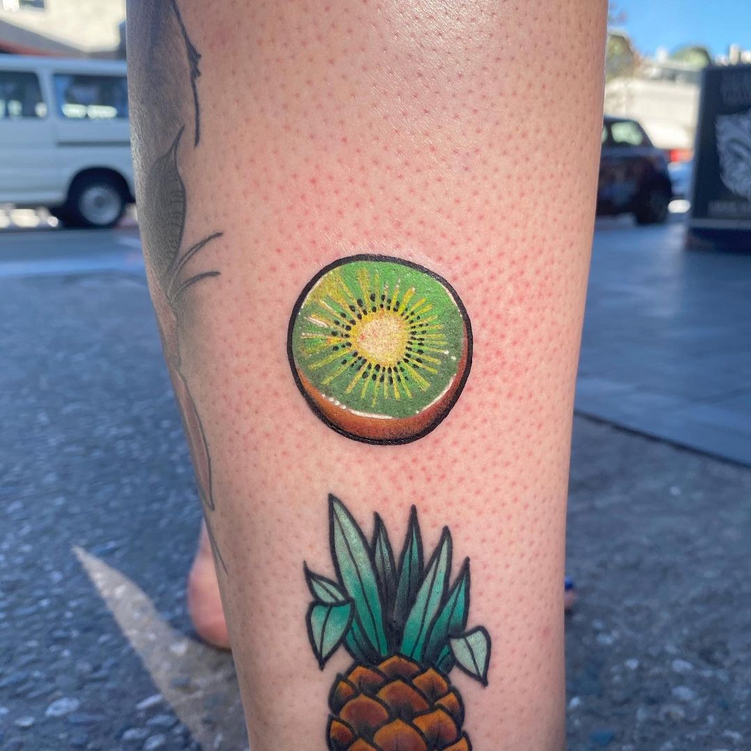 Bright and bold kiwi fruit tattoo by @skadi.ink.